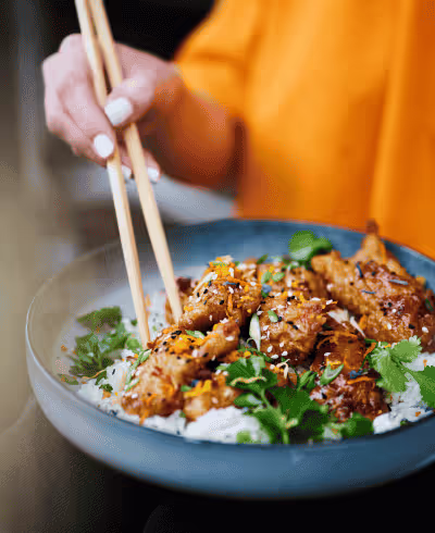 a woman eating rice with fish