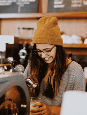 a woman making coffee to drink